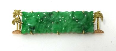 A gold mounted carved jade panel Brooch, with textured palm tree border, jade untested.