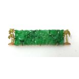 A gold mounted carved jade panel Brooch, with textured palm tree border, jade untested.