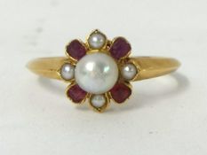 A ruby and pearl cluster Ring, the central bead, untested, bordered by 1/2 pearls and mixed cut