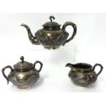 A Chinese silver tea set Hung Chong Shanghai decorated with a dragon in relief and bamboo handles