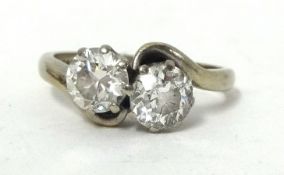 An 18ct white gold two stone diamond crossover Ring, claw set with an old cut and an old brilliant