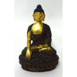 A gilded bronze figure of Buddha, seated in dhyanasana on a lotus base, wearing a sanghati draped