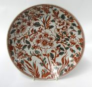 An antique Chinese shallow dish decorated in red and green, with stylised flowers, diameter 35cm.