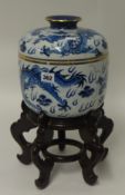 A Chinese reproduction blue and white jar and cover on a carved wood stand