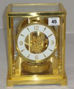 A Jaeger Le Coutre Atmos clock and booklet, height 22cm.
