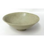 A Chinese celadon bowl, decorated with incised wavy design, probably Song dynasty, with small footed