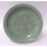 A Chinese celadon glazed dish, probably Song dynasty, pale green of shallow form, with underglaze