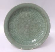 A Chinese celadon glazed dish, probably Song dynasty, pale green of shallow form, with underglaze