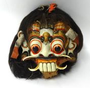 A large and ornate carved wood Ramayana mask.