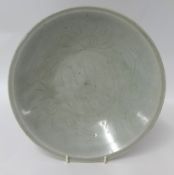 A Chinese celadon glazed pottery dish, of circular form with incised decoration, diameter 27cm .