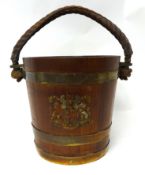 A Geo V brass bound wood fire bucket with rope handle and crest.