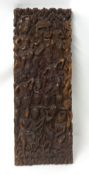 A carved wood Balinese panel decorated with figures and fruits, 96cm x 36cm.