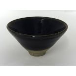 A Jian ware conical tea bowl, in a deep brown glaze, on a plain stoneware foot rim, probably Song
