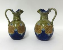 Pair of Royal Doulton decorative jugs by Maud Bowden 1894, 17cm.