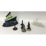 Collection of six small marble lighthouses, metal modern plaque promoting Titanic, and a glass cruet