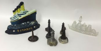 Collection of six small marble lighthouses, metal modern plaque promoting Titanic, and a glass cruet