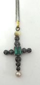 A 19th century continental silver cross pendant, claw set with an emerald cut emerald, lasque cut