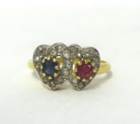 An 18ct gold, ruby, sapphire and diamond double heart ring, claw set with a mixed cut ruby and