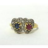 An 18ct gold, ruby, sapphire and diamond double heart ring, claw set with a mixed cut ruby and