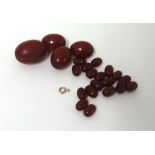 A red amber bead necklace, composed of graduated beads, unstrung and untested.