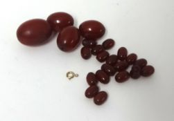 A red amber bead necklace, composed of graduated beads, unstrung and untested.