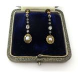 A Victorian pair of pearl and diamond ear pendants, the oval half pearl bordered by rose cut