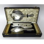 A silver five piece dressing table set, Birmingham 1929, cased and a silver mounted glove