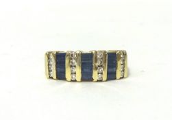 A 14kt gold, sapphire and diamond panel ring, set with three rows of baguette cut sapphires with