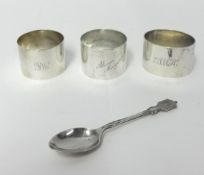 A silver napkin ring, London 1945, inscribed, two other napkin rings and a spoon, weight 4.5 oz.