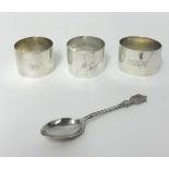A silver napkin ring, London 1945, inscribed, two other napkin rings and a spoon, weight 4.5 oz.