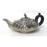 A George IV silver bachelor tea pot, by T.B, London 1824, with embossed floral and shell decoration,