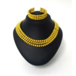 Ilias Lalaounis; An 18ct gold collar and bangle, composed of three rows of uniform textured