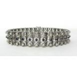 An 18ct white gold, sapphire and diamond bracelet, claw set with three rows of sapphires and