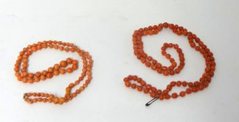 A coral bead necklace, composed of graduated beads of a pale pink hue and another composed of