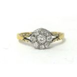 An 18ct gold and diamond cluster ring, claw set with an old cut stone bordered by smaller stones,