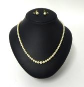 A single row cultured pearl necklace, composed of graduated beads, together with a pair of