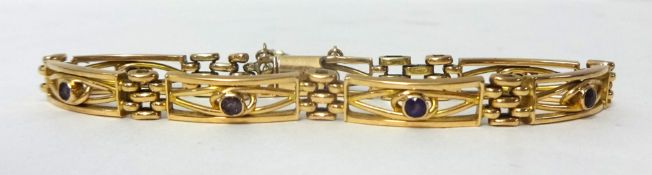 An Edwardian gold and amethyst bracelet, stamped 15ct, composed of openwork panels collet set with