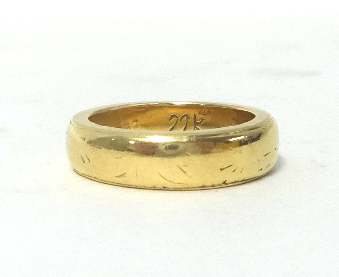 A wedding band, stamped 22K, size M, weight 10 grams.
