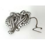 A silver set double clip Brooch, claw set with white stones, of scroll design, stamped 3CP, ENGLAND,