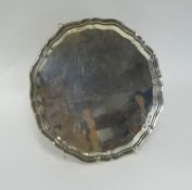 A silver salver, by Viners, Sheffield 1958, with a wavy border, raised on three feet, diameter 26