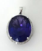 A 14k white gold amethyst and diamond pendant, claw set with a mixed cut stone estimated to weigh