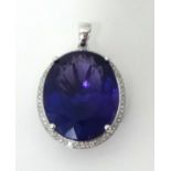 A 14k white gold amethyst and diamond pendant, claw set with a mixed cut stone estimated to weigh