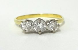 A three stone diamond ring, claw set with graduated brilliant cut stones, total diamond weight