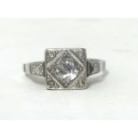 A single stone white metal and diamond ring, box set with an old cut stone with rose cuts to the