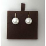 A pair of continental gold mounted cultured pearl ear rings, set with a 12 mm bead.