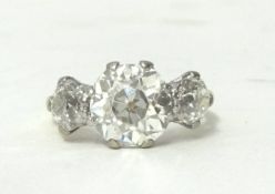 A three stone diamond ring, claw set with old cut stones, the central stone weighing approximately