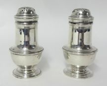A pair of silver bun peppers, London 1918, of baluster form, raised on a pedestal foot, height 10