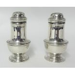 A pair of silver bun peppers, London 1918, of baluster form, raised on a pedestal foot, height 10