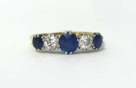 An 18ct gold sapphire and diamond five stone ring, claw set with mixed and brilliant cut stones,