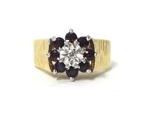 A 9ct gold garnet and diamond cluster ring, finger size N 1/2, weight 5.4 grams.